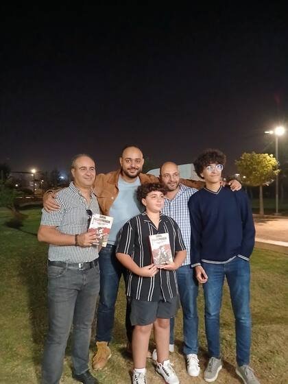 Un groupe de lecteurs réunis le soir, deux exemplaires en main