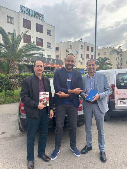 Trois lecteurs réunis autour du livre en ville