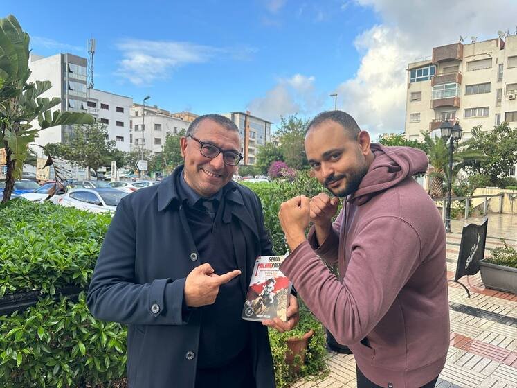 Un lecteur pose avec le livre, poings levés