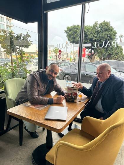 Youssef Ghalem dédicace un exemplaire du livre en café